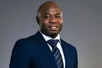 Emmanuel Amunike suited in black